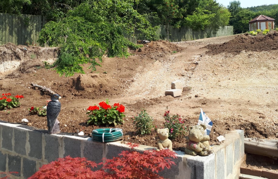 The same garden before work, bare earth slope and new block retaining wall during excavation by Level Groundworks